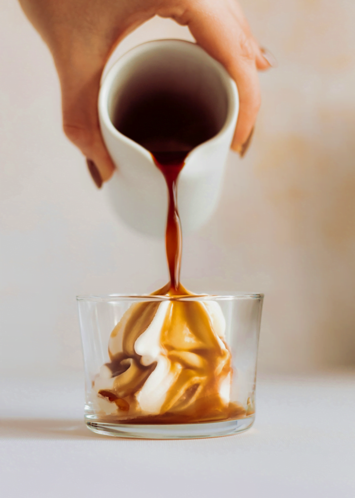 A head on picture of an espresso poured onto a mound of ice cream in a clear glass.
